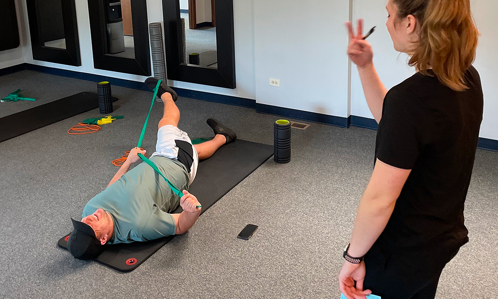 Two people in a functional rehab session