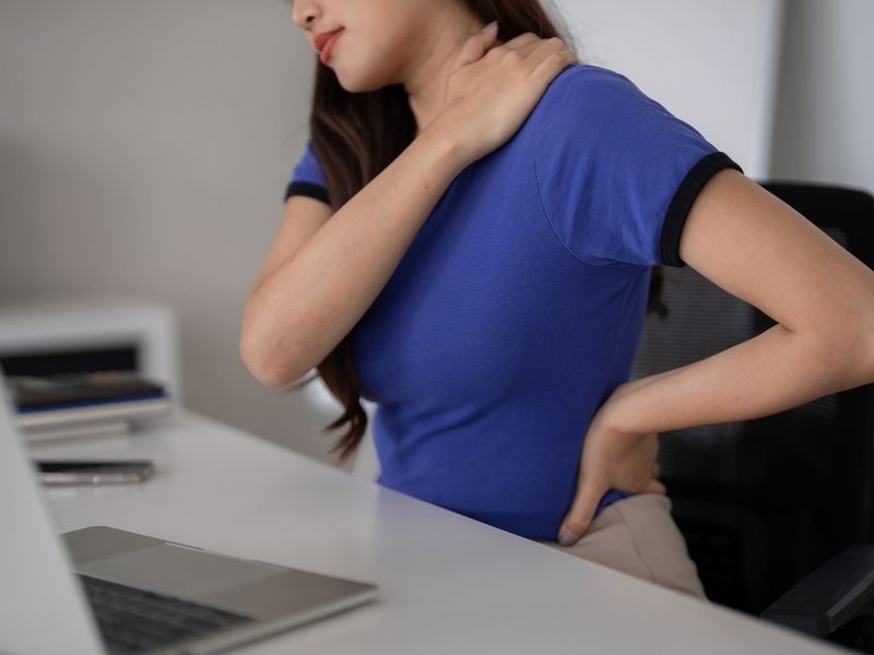 woman holding her shoulder and hip in pain