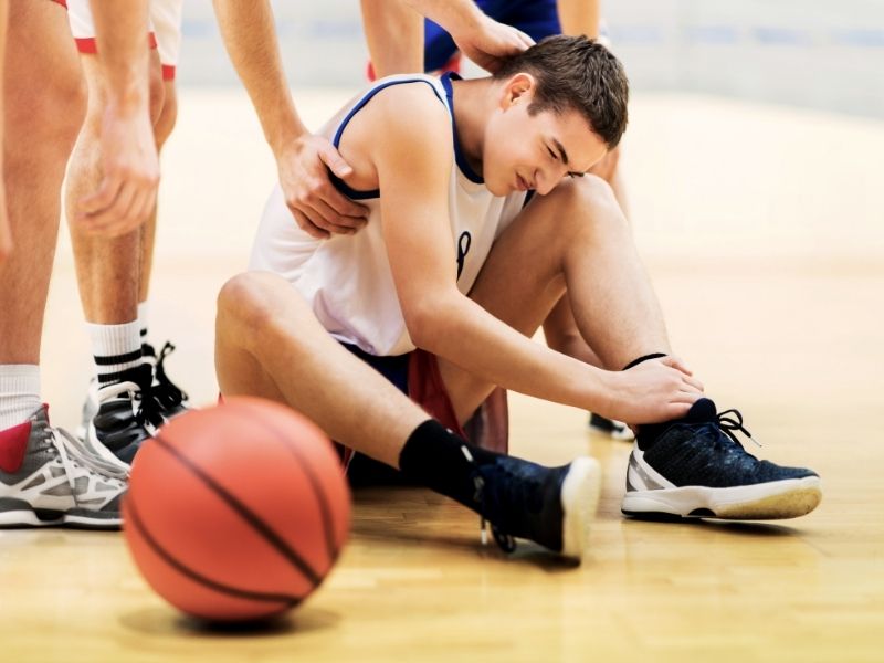 basketball player experiencing an ankle injury during a game