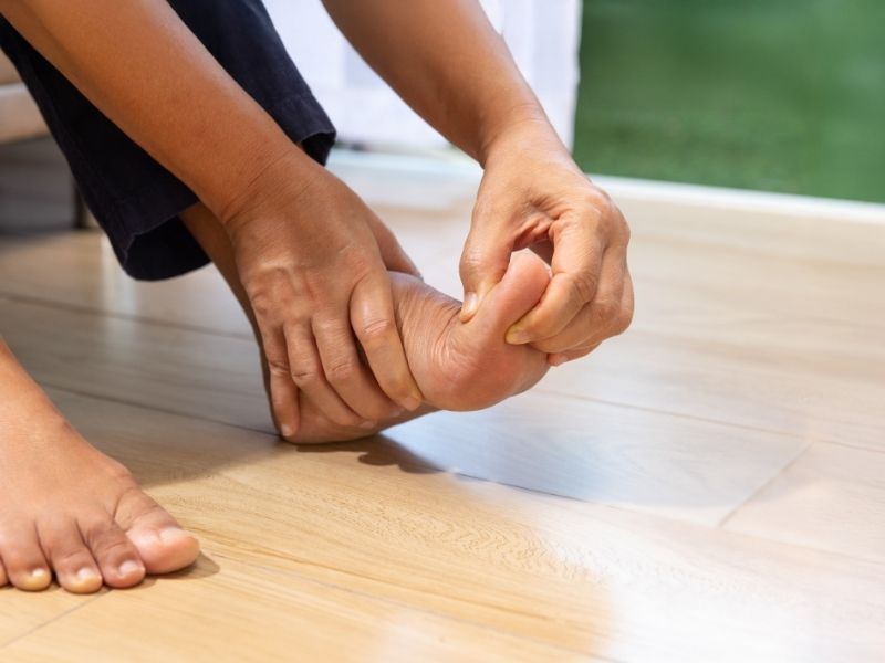 person holding foot in pain