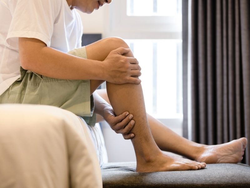 man holding his leg in pain