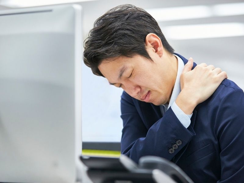 man holding his shoulder in pain