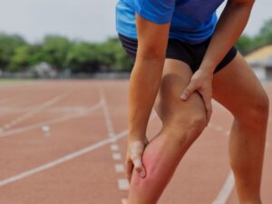 runner holding his lower leg in pain