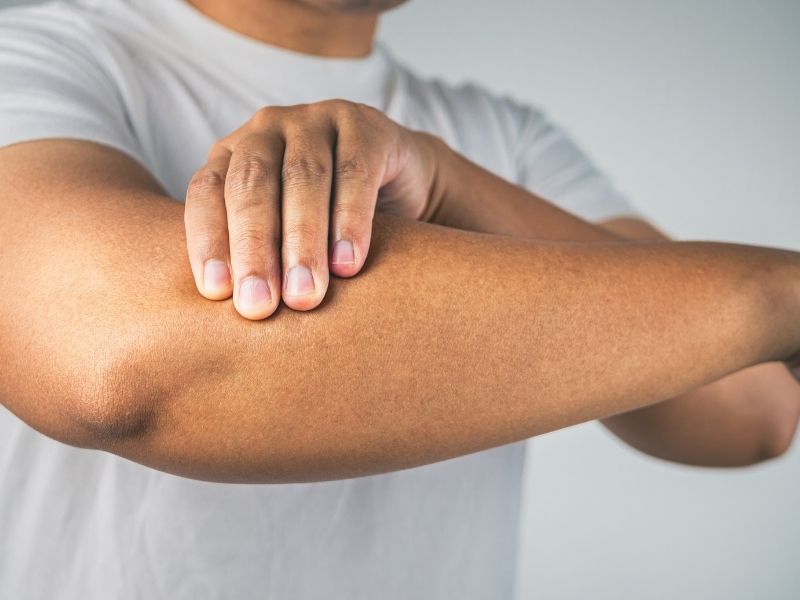 man holding elbow in pain