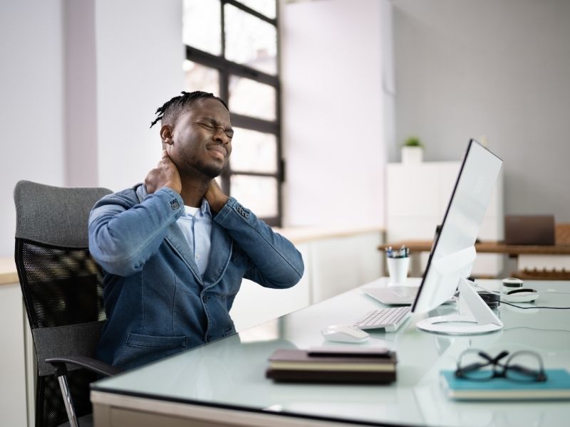 man holding his neck while in pain