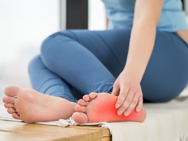 woman holding foot in pain