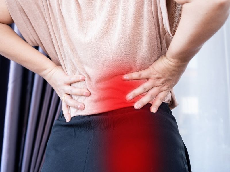 woman holding her lower back and hips in pain